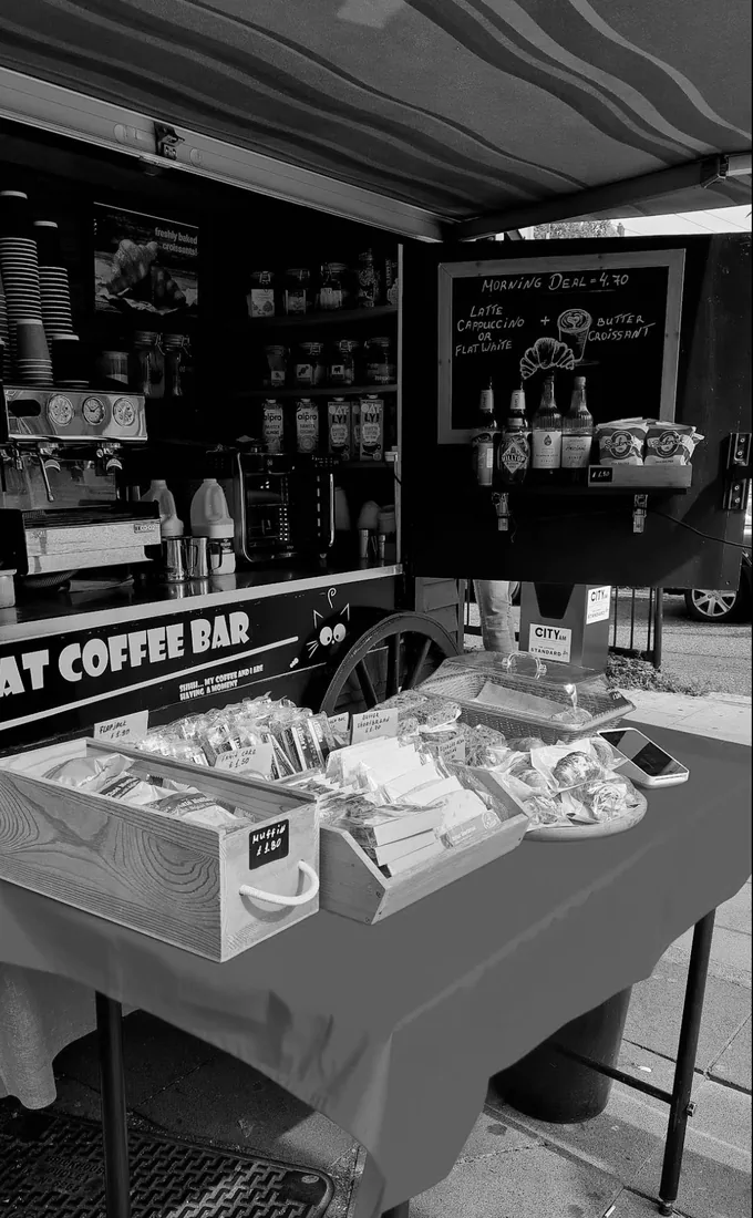 The Mad Cat counter, with pastries and its hand-lettered sign